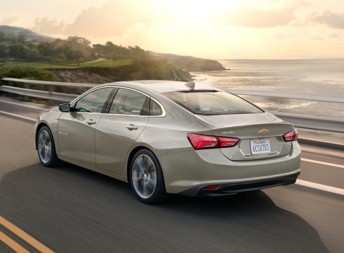 2024 Chevy Malibu driving along an oceanside highway