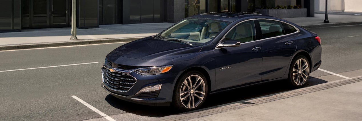 2024 Chevy Malibu parked along the side of a city street