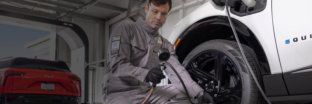 A mechanic servicing an electric fleet vehicle