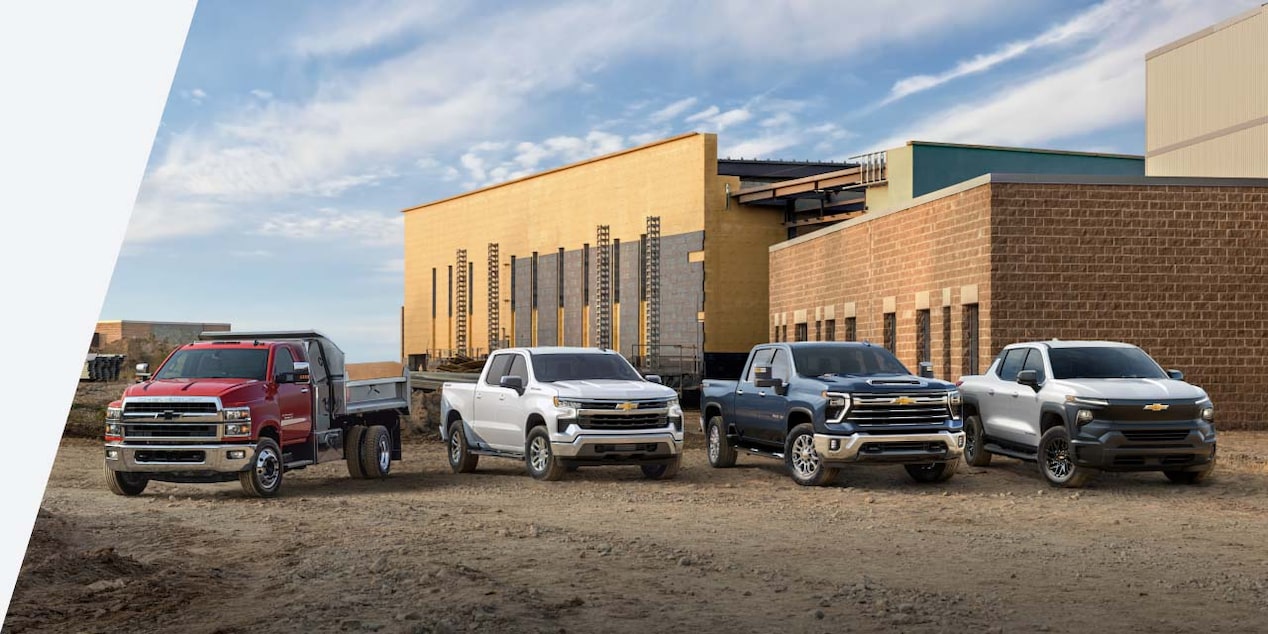 Four GM Trucks parked on a job site.