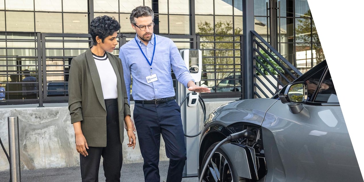 Image of a vehicle with an electric charger and two people next to it in discussion