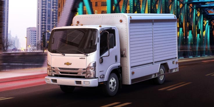 Three-Quarters Front View of the 2023 Chevrolet Low Cab Forward Truck Driving on a Bridge