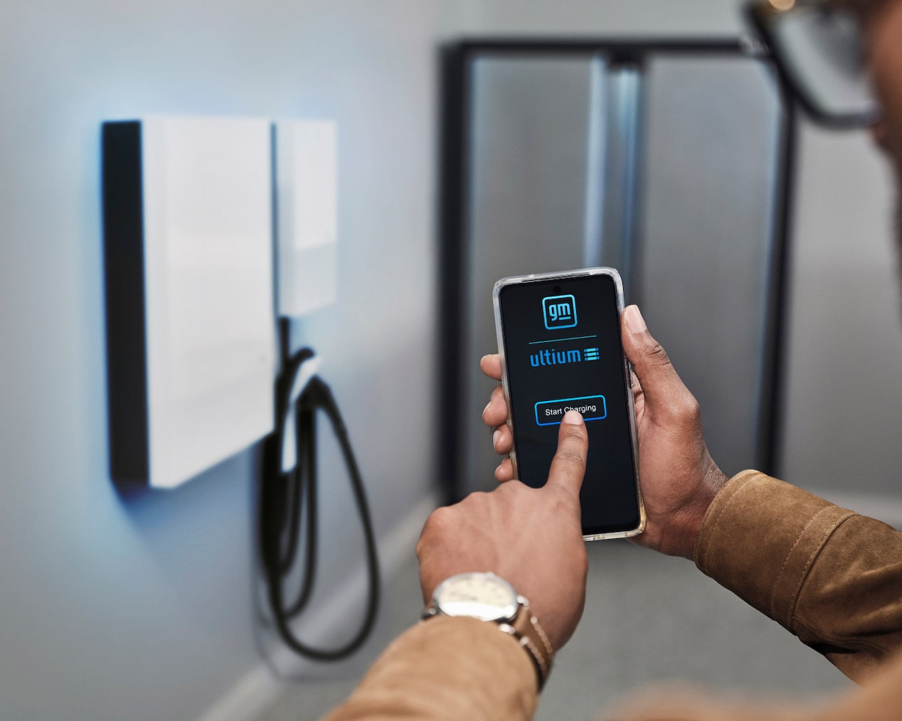 Man Using his Smartphone for Smart Home Tech with his EV at Home Charging Station