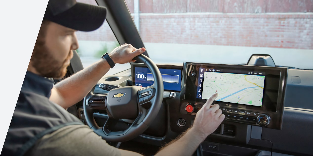 An interior-view of a man using the infotainment center within the 2024 Chevrolet Brightdrop