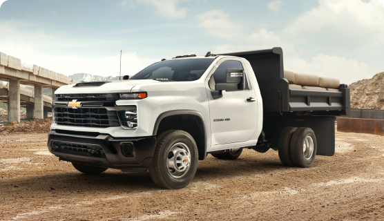 Front Three-Quarters View of a Chevrolet Silverado Heavy Duty Truck With Dump Truck Upfit Parked at a Job Site