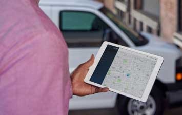 Close-up of a Person Holding a Tablet with a Map Application In Use