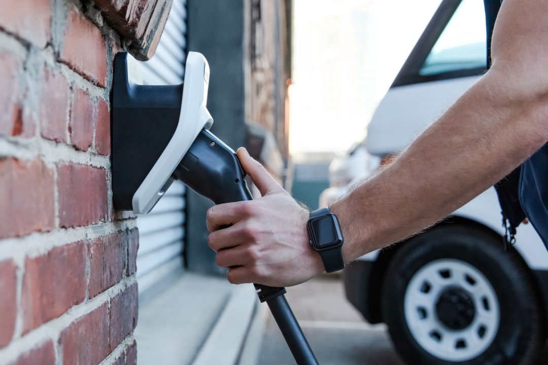 Close-up shot of person holding EV charger