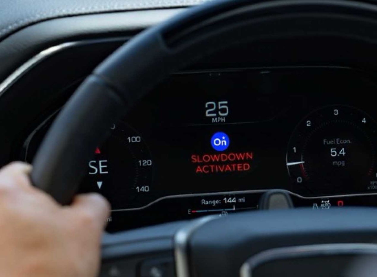 Close-up of OnStar "Slow Down" Feature Activated on a Vehicle's Digital Dashboard